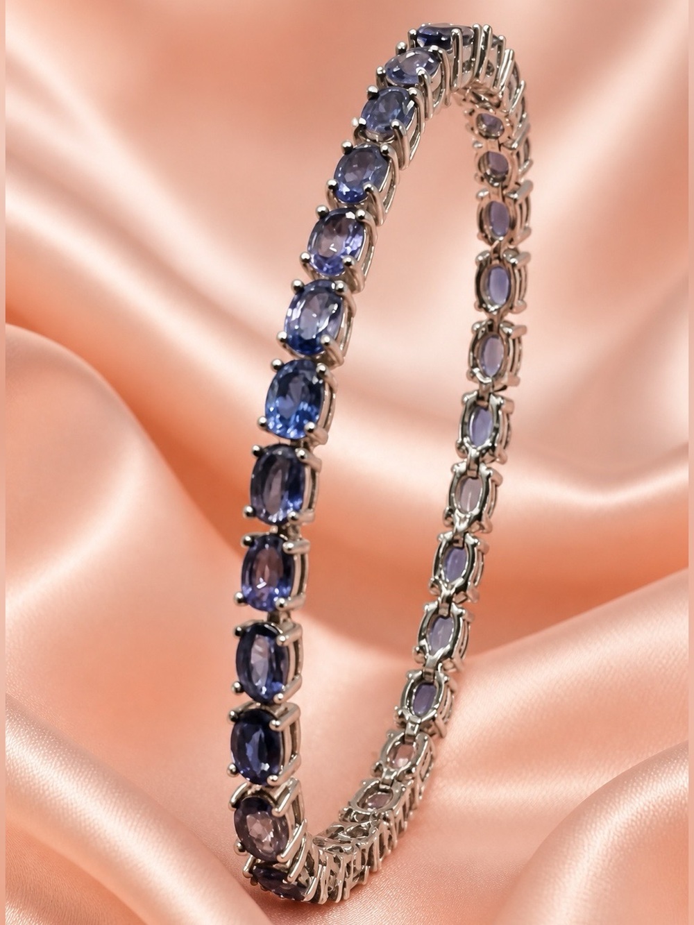 Genuine 13.5ctw Iolite tennis bracelet set in rhodium over S925. 7” long. NEW!